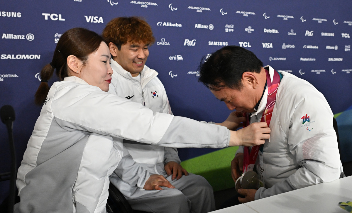 휠체어컬링 백혜진(왼쪽)과 이용석이 11일(현지시간) 이탈리아 코르티나담페초 컬링 올림픽 스타디움에서 열린 2026 밀라노 코르티나 패럴림픽 휠체어컬링 믹스더블에서 은메달을 차지한 뒤 윤경선 대한장애인컬링협회장에게 메달을 걸어주고 있다. 2026.03.12. 코르티나=사진공동취재단