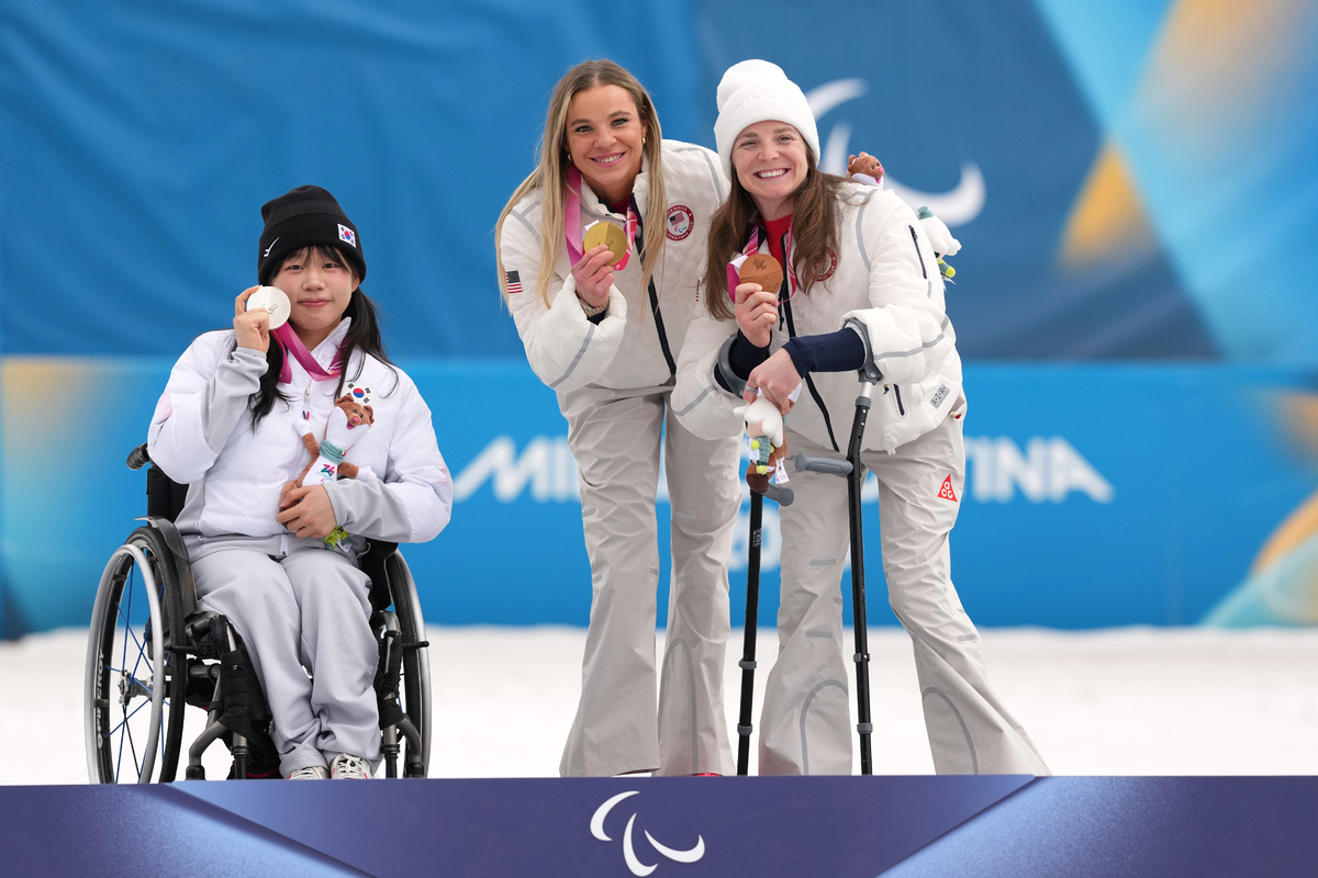 김윤지(왼쪽)가 11일(현지 시간) 이탈리아 테세로 크로스컨트리 스타디움에서 열린 2026 밀라노·코르티나담페초 동계 패럴림픽 크로스컨트리 스키 여자 10㎞ 인터벌 스타트 좌식 결승에서 은메달을 차지한 뒤 시상대에서 포즈를 취하고 있다. 테세로(이탈리아)=AP/뉴시스 Silver medalist Kim Yunji, of South Korea, from left, gold medalist Oksana Masters, of the United States, and bronze medalist Kendall Gretsch, of the United States, pose on the podium after the cross country skiing women's 10Km interval start sitting final at the 2026 Winter Paralympics, in Tesero, Italy, Wednesday, March 11, 2026. (AP Photo/Evgeniy Maloletka) 크로스컨트리여자 10km 인터벌스타트 좌식 결승